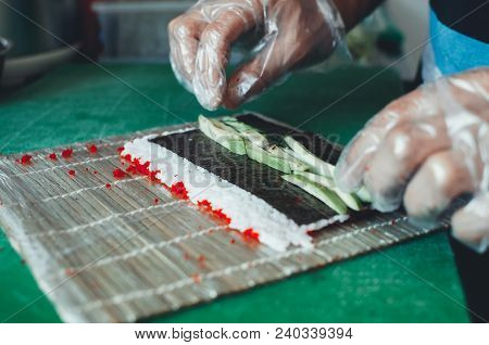 Professional Chef, Chef The Process Of Making Sushi Rolls, Spins Bamboo Mat And Cut Slices