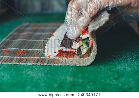 Professional Chef, Chef The Process Of Making Sushi Rolls, Spins Bamboo Mat And Cut Slices