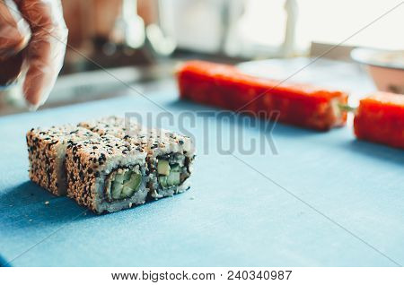 Professional Chef, Chef The Process Of Making Sushi Rolls, Spins Bamboo Mat And Cut Slices
