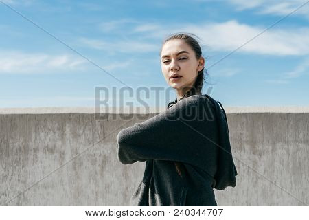 Young Zealous Girl In Black Stylish Clothes Kneads Muscles Before Training In The Open Air