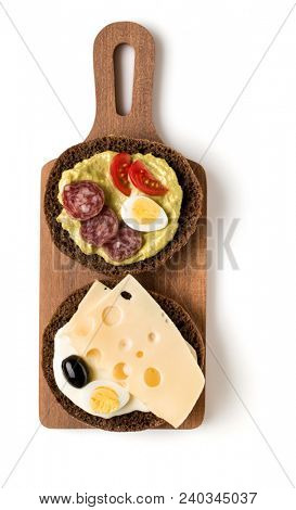 Open  faced sausage sandwich canape or crostini on a wooden serving board  isolated on white background closeup. Top view.