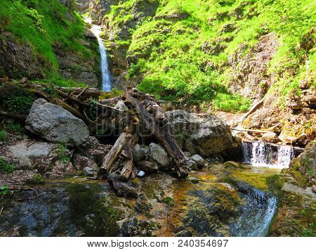Grunau, Austria. Jun 14 2017: Waterfall And Calm Pond In Bush Forest.