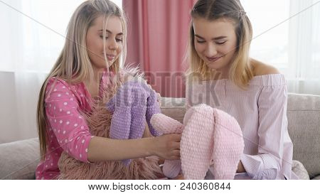 Infantile Lifestyle. Teenage Girls Holding Toy Bunnies. Youth Leisure Communication. Childish Behavi