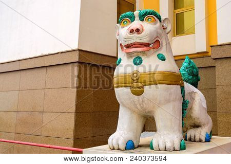 Tibetan Snow Lion With Turquoise Mane In Front Of Entrance To Buddhist Temple. Symbol Of Snow Himala