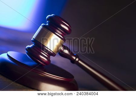 Law Theme. Mallet Of The Judge On Wooden Desk And Blue Background. Place Fort Ext.
