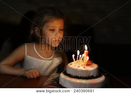 Girl With Birthday Cake Blowing Caldles In Darkness