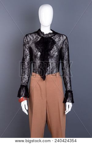 Female Mannequin In Stylish Lace Blouse. Women Fashion Design Black Blouse And Brown Trousers On Man