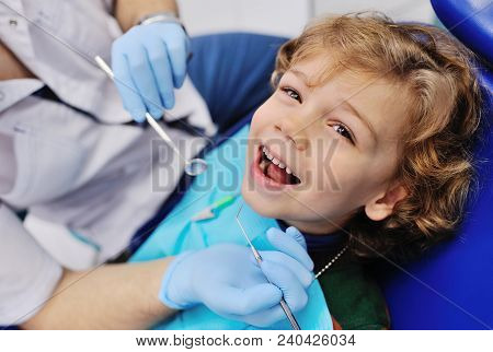 Smiling Child Sitting In A Blue Chair Dental