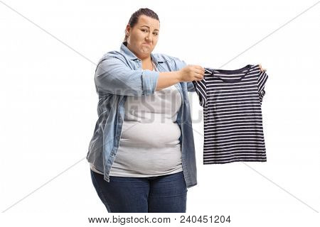 Upset overweight woman holding a shrunken shirt isolated on white background