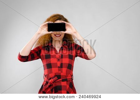Charming Young Girl In A Checkered Cloth On A Gray Background