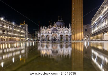Basilica in San Marco square in Venice with reflection at night during the high tide, or aqua alta, that flooded the square with sea water