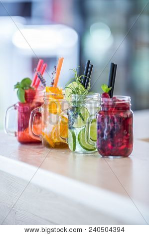 Various Lemonades In Mason Jars With Orange Lime Lemon Otange Strawberries And Fresh Fruit Fruits