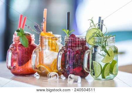 Various Lemonades In Mason Jars With Orange Lime Lemon Otange Strawberries And Fresh Fruit Fruits