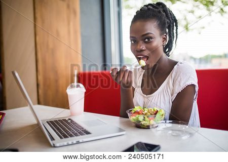 Photo Of Beautiful Woman Have Lanch Eat Salad At Dinner Sitting At Cafe. Young African American Woma