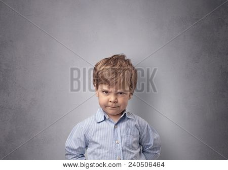 Adorable little boy portrait with empty grey wall background