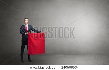 Businessman standing with red toreador cloth in his hand in an empty room