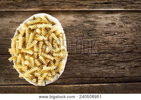Raw Rotini Or Fusilli Pasta In Textile Bag, Photographed Overhead On Rustic Wood (selective Focus, F
