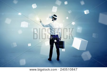 Handsome businessman with vr goggle and falling white cubes around