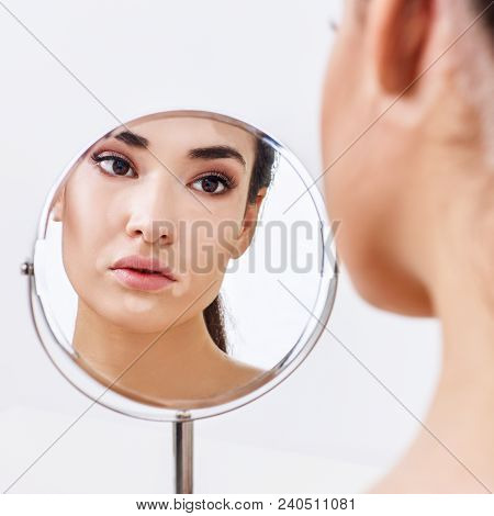 Beautiful Woman With Vitiligo Looking On Her Reflection In The Mirror. Over White Background.