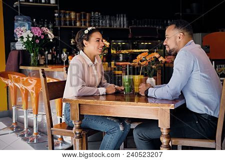 Black American Couple Talks And Drinks, Fresh Juice At A Cafe