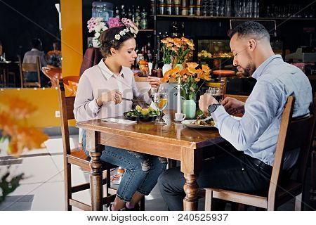 Black American Male And Female Eating Vegan Food In A Restaurant.