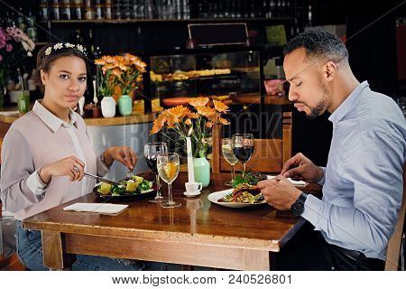Black American Male And Female Eating Vegan Food In A Restaurant.