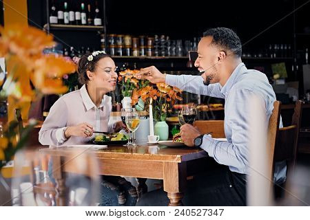 Black American Male And Female Eating Vegan Food In A Restaurant.