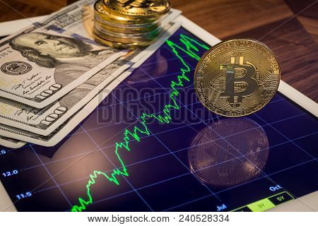 Cryptocurrency And Us 100 Dollar Banknotes, Focus Gold Bitcoin Reflect On Tablet Screen Show Green P