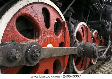 Wheels Of An Old Functioning Steam Locomotive With Drawbar And Crank Mechanism Closeup