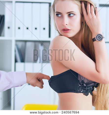 Man's Hand Pulls Bra Out Of The Beauitiful Secretary In Office Background. Flirt Or Harassment Conce