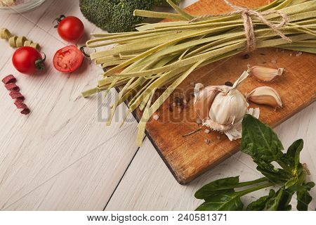 Raw Handmade Green Tagliatelle With Spinach Juice, Broccolli, Tomatoes, Garlic And Spices On White W