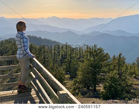 Ordinary Middle Age Woman Hiker On The Balcony Of Fire Watch Tower Enjoying Beautiful Views Of Mount