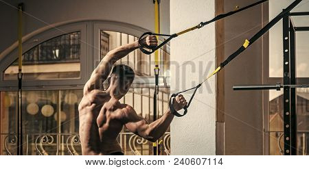 Sportsman, Athlete, Muscular Macho Does Exercise With Trx Loops, Window On Background. Man With Nude