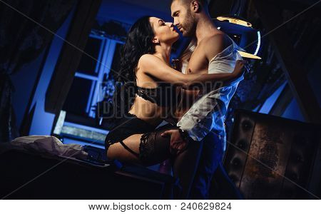 Couple Indoors. Sensual Brunette In Black Lingerie And Handsome Man Kissing. Office Romance Concept