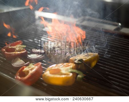 Master chef cooking delicious grilled meat steak with vegetables on a barbecue