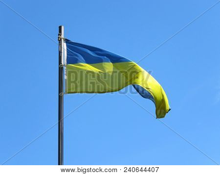 National Flag Of Ukraine On A Flagpole In Front Of Blue Sky.