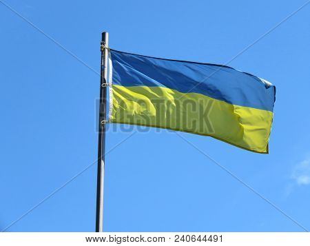 National Flag Of Ukraine On A Flagpole In Front Of Blue Sky.