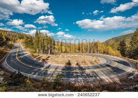 Highway with hairpin turn (switchback) at autumn sunny day in Rocky Mountain National Park. Colorado, USA. 
