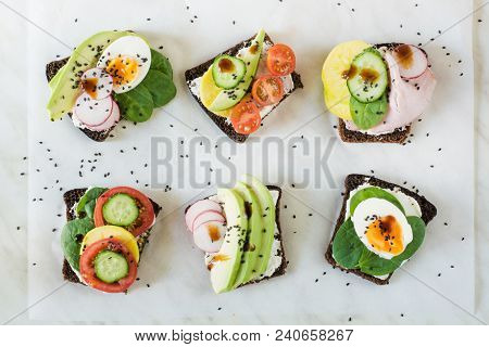 Different Sandwiches With Vegetables, Eggs, Avocado, Tomato, Rye Bread On Light Marble Table. Top Ve
