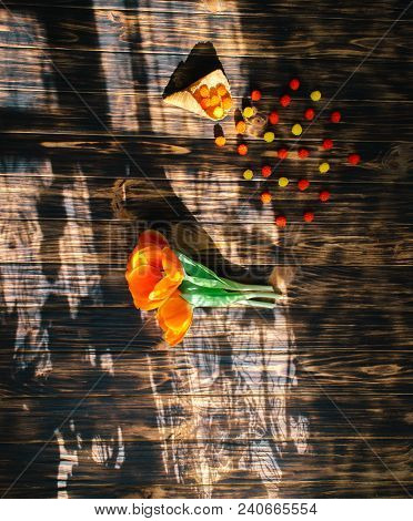 Tulips With Sweets In A Waffle Horn On A Wooden Background.