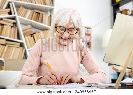 Study Goal. Jovial Senior Woman Studying While Using Pencil