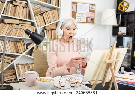 Speak Chinese. Appealing Mature Woman Listening To Audio And Carrying Phone