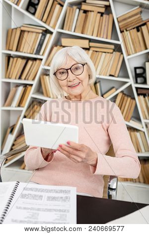 Popular Courses. Satisfied Senior Woman Using Tablet While Staring At Camera
