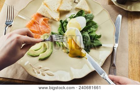 Healthy Breakfast - Poached Eggs With Smoked Salmon, Avocado, Spinach And Crusty Baguette. Woman Eng