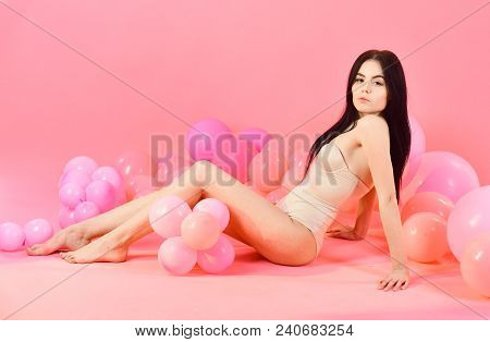 Woman In Beige Bustier, Bodysuit Posing Near Air Balloons, Pink Background. Girl On Pensive Face Loo