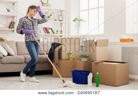 New Home Cleaning. Young Tired Woman Tidying Up After Moving To New Apartment. Girl With Various Det