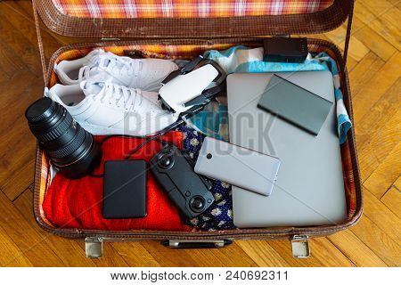 Valise With Gadgets And Wear Inside. Travel Concept. Overtop View