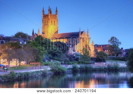 Worcester Cathedral Floodlit On A Spring Evening And Reflected In The River Severn.