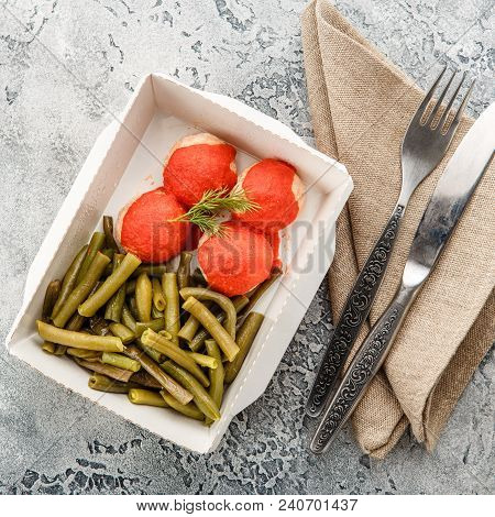 Boiled String Beans And Fish Balls In Sauce In A Lunchbox On A Gray Background. Healthy Food Deliver