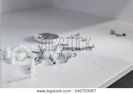 New Silver Tapping Screws Lying On White Shelf